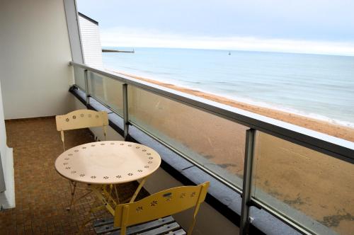 two chairs and a table on a balcony overlooking the ocean at L'Esperluette - magnifique vue mer et balcon in Courseulles-sur-Mer
