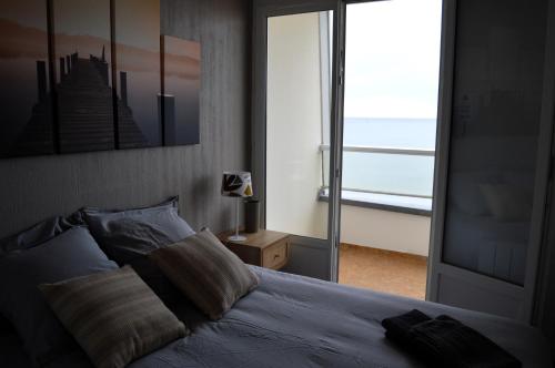 - une chambre avec un lit et une vue sur l'océan dans l'établissement L'Esperluette - magnifique vue mer et balcon, à Courseulles-sur-Mer