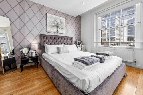Un dormitorio con una cama grande y una ventana en 3 Bedroom Apartment in Haymarket Central London Sleep 10 HY2, en Londres
