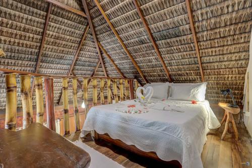 a bedroom with a bed in a straw hut at Aldeia da Mata Ecolodge in Serra Grande