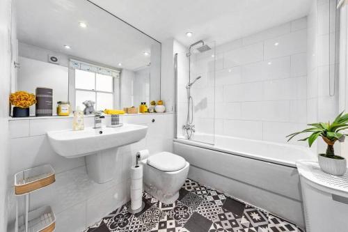 a bathroom with a sink and a toilet and a tub at 3 Bedroom Apartment in Haymarket Central London Sleep 10 HY2 in London