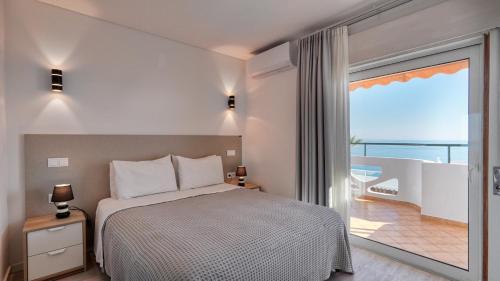 a bedroom with a bed and a large window at Guest House Dianamar in Albufeira