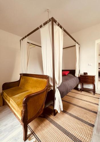 une chambre avec un lit à baldaquin et une chaise dans l'établissement Villa Ermetica, à Breil-sur-Roya