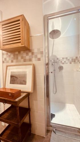 une salle de bain avec une douche avec une porte vitrée dans l'établissement Villa Ermetica, à Breil-sur-Roya