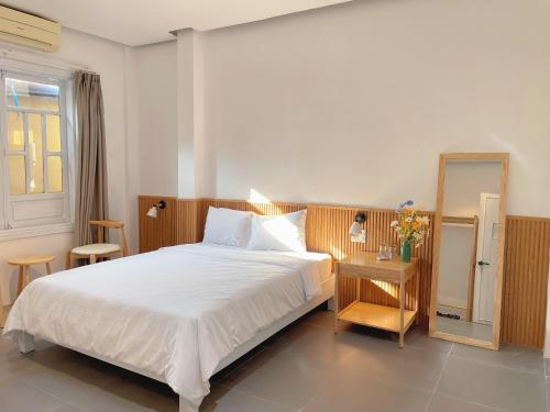 Un dormitorio con una gran cama blanca y una ventana en LUX hotel, en Thôn Lại Thê