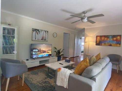 a living room with a couch and a tv at Spacious 4-Bedroom house in a shared property in Harristown