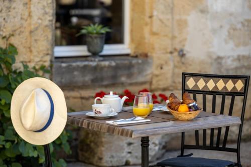 a table with a basket of food and a hat on it at Château Fleur de Roques - Puiseguin Saint Emilion in Puisseguin