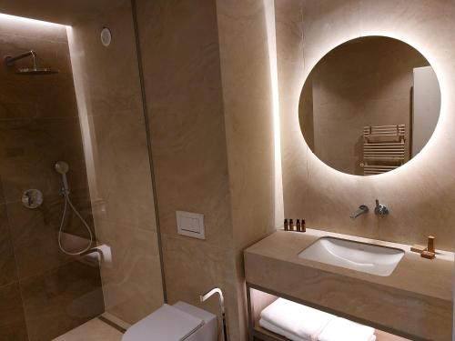 a bathroom with a sink and a mirror at Tivoli Boutique Inn in Ljubljana