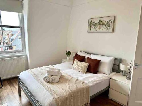a white bed in a room with a window at One Bed Apartment- Muswell Hill in London