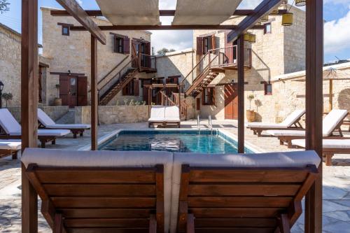 a pool in the middle of a patio with two chairs at Stone Court Boutique Studios in Paphos City