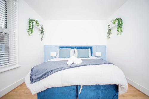 a bedroom with a large bed with a blue headboard at 3 bedroom-Contractors-Professionals in Gillingham