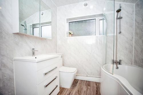 a bathroom with a sink and a tub and a toilet at 3 bedroom-Contractors-Professionals in Gillingham
