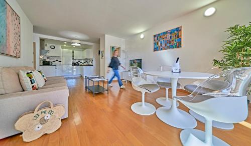une femme traversant un salon avec une table et des chaises dans l'établissement Saint Antoine-City center St-Tropez-TerraceParking, à Saint-Tropez