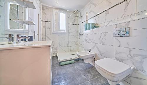 une salle de bain blanche avec des toilettes et un lavabo dans l'établissement Saint Antoine-City center St-Tropez-TerraceParking, à Saint-Tropez
