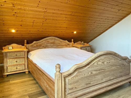 een houten bed in een kamer met een houten plafond bij Urlauberdorf Haus 51a in Boltenhagen