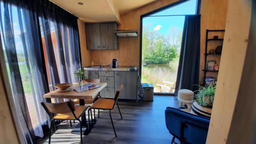 eine Küche und ein Esszimmer mit einem Tisch und Stühlen in der Unterkunft Tiny house De Wylp in Westergeest