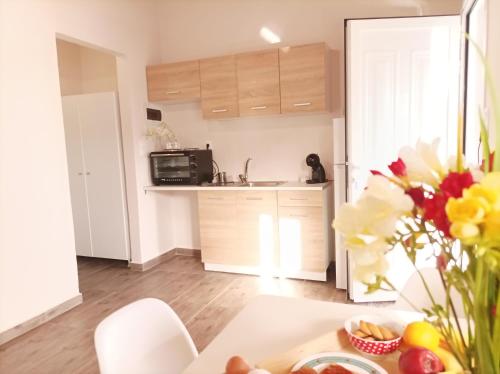 a kitchen with a table with a vase of flowers at V&E's Apartments in Pigádhia