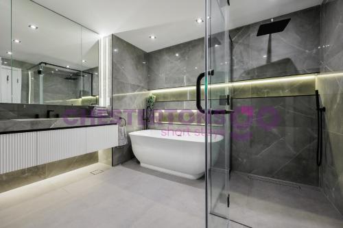 a bathroom with a tub and a glass shower at Chestertons Go - Residences 1 - Fountain View Penthouse in Dubai