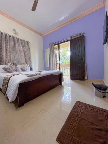 a bedroom with a large bed and a large window at The Ruby Park in Yelagiri