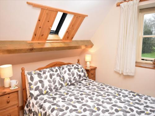 um quarto com uma cama e uma janela em 2 Bed in Cirencester CC094 