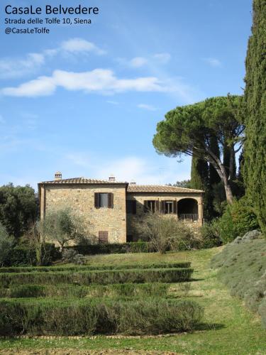 a stone house in the middle of a field at CasaLeTolfe Residence in Siena