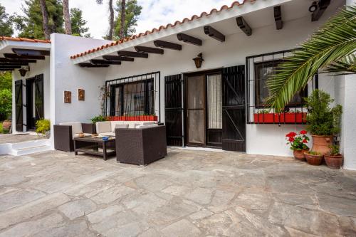 a white house with a patio and a porch at The Gift Sani Villa in Sani Beach