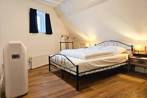 a bedroom with a bed and a radiator and a window at Vakantiewoning Veere VE01 in Veere