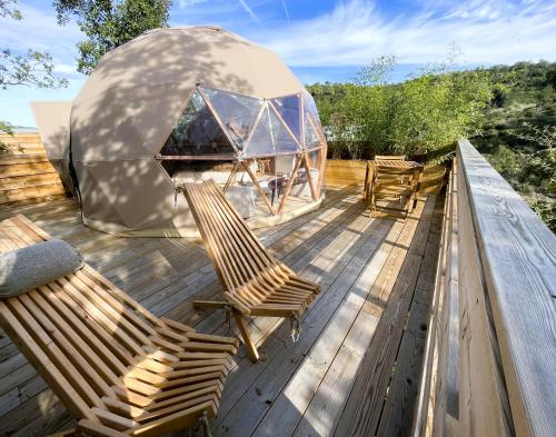 a deck with two chairs and a dome tent at Dôme Sirius - Provence étoilée in Rocbaron