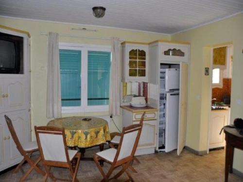 Il comprend une cuisine avec une table, deux chaises et une table. dans l'établissement Bel appartement 3 pièces face à la plage de Gigaro, à La Croix-Valmer