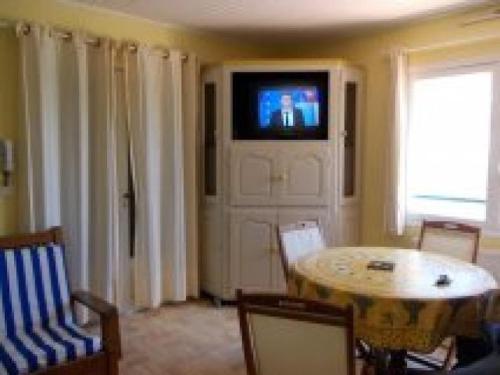 un salon avec une table et une télévision sur un mur dans l'établissement Bel appartement 3 pièces face à la plage de Gigaro, à La Croix-Valmer