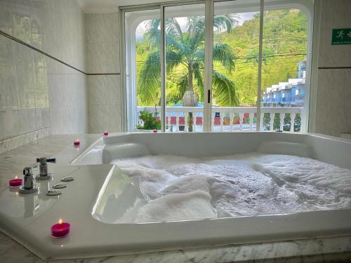 a white bath tub with a large window in a bathroom at Juan de la vega in La Vega