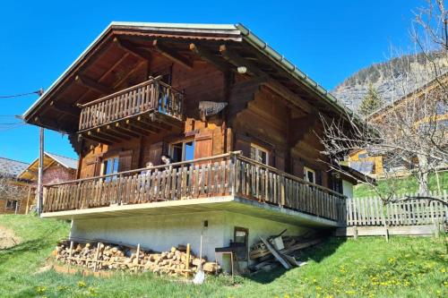 um casal na varanda de uma casa de madeira em Savoyard nest with Mont Blanc view em Flumet