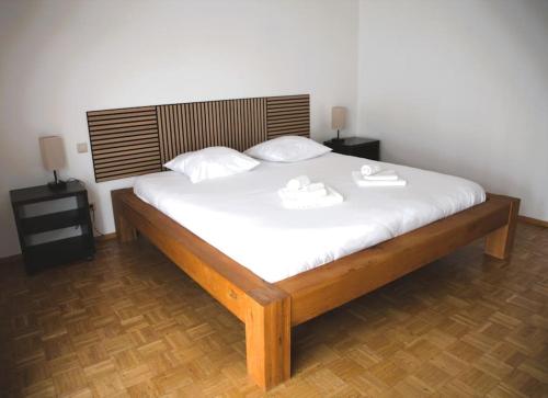 a bedroom with a large bed with white sheets at Cozy 3 bedroom house with 11 kw electric car charger in Hesperange