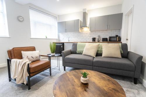 a living room with a couch and a table at April Disc - Long Stay - Contractors in Swindon