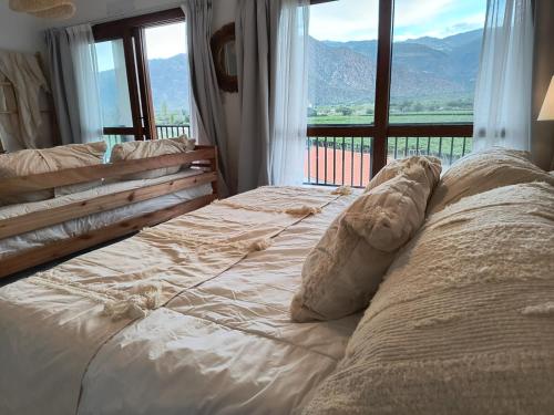 a large bed in a room with a large window at Chadel Management Cafayate in Cafayate