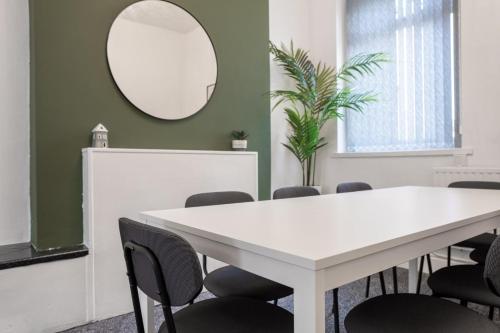 a white table and chairs in a room with a mirror at Spacious 4-Bedroom Apt | Pool Table in Cardiff
