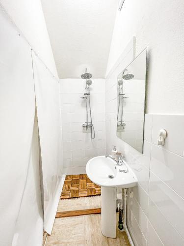 a white bathroom with a sink and a mirror at PINIALE GLAMPING TRIB in Bughea de Jos