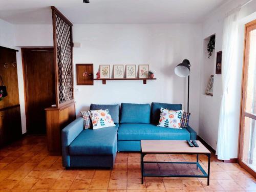 - un salon avec un canapé bleu et une table dans l'établissement MadreSila Home, à Camigliatello Silano