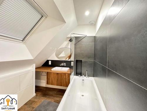 a bathroom with a bath tub and a sink at Evasion in Saint-Brieuc