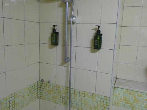 um chuveiro com duas garrafas na parede em Ruby Star Hostel Loft Bed 21 no Dubai