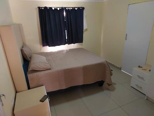 ein kleines Schlafzimmer mit einem Bett und einem Fenster in der Unterkunft BERG STREET APARTMENTS in Johannesburg