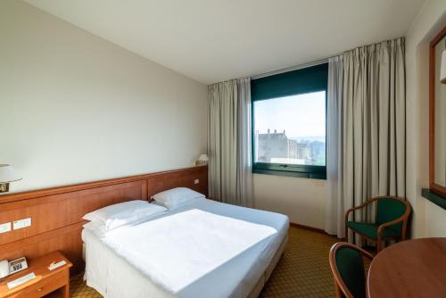 a hotel room with a bed and a window at Phi Hotel Emilia in Ozzano dell Emilia