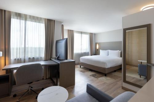 a hotel room with a bed and a desk with a television at Residence Inn by Marriott Playa del Carmen in Playa del Carmen