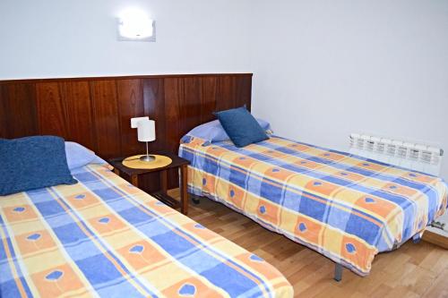 dos camas sentadas una al lado de la otra en una habitación en Apartamento Casovall, en Esterri d'Àneu