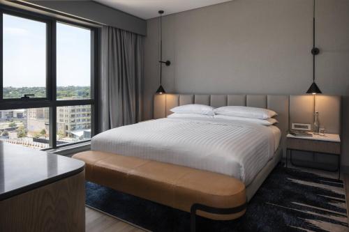 a bedroom with a bed and a large window at Marriott Executive Apartments Johannesburg, Melrose Arch in Johannesburg