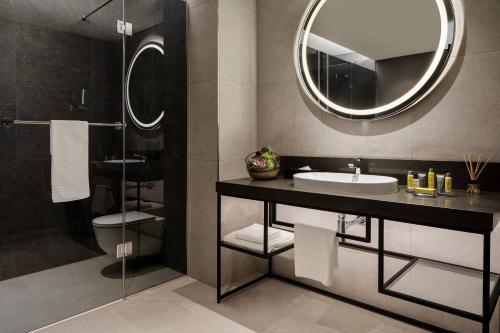 uma casa de banho com um lavatório e um espelho em Marriott Executive Apartments Johannesburg, Melrose Arch em Joanesburgo