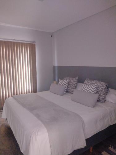 a bedroom with a large white bed with pillows at Tomero Apartamento in Tupungato