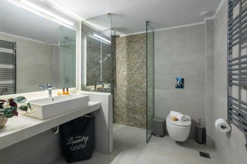 uma casa de banho com um lavatório, um chuveiro e um WC. em Casa George em Rethymno Town