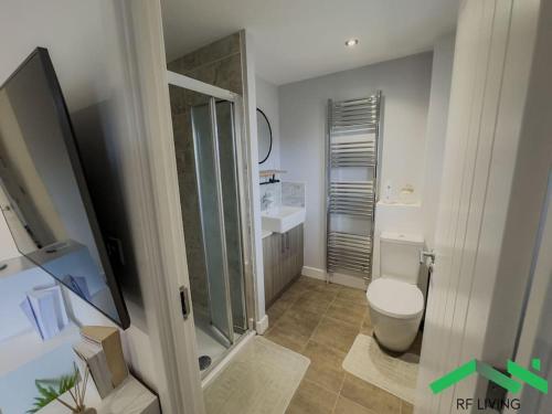 La salle de bains est pourvue de toilettes et d'une douche en verre. dans l'établissement Na Private Room Private Bathroom in New Waltham Na, à New Waltham