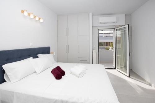 um quarto com uma cama branca e uma toalha vermelha em Casa George em Rethymno Town